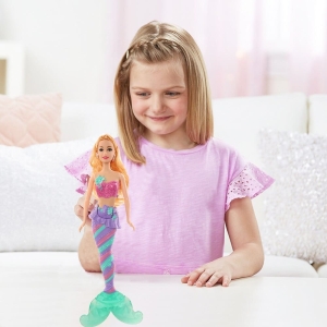 Barbiedocka med flipper för snygg tjej spelas av en tjej i ett hus