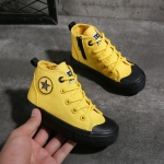 Converse-skor med svarta och gula stjärnor