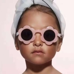 Moderiktiga solglasögon med rosa blommor för flickor, bärs av en flicka