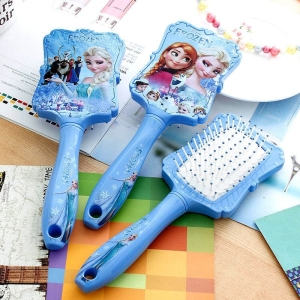 Blå Snow Queen-hårborste för flickor på ett bord med en anteckningsbok