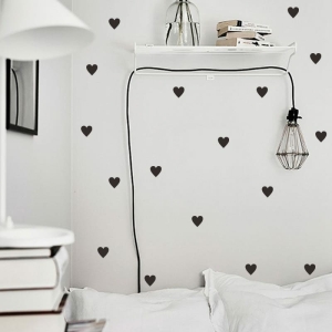 Klistermärke i form av ett svart hjärta, på en vägg i ett hus.