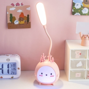 Kaninformat LED-nattljus för flickor i rosa på ett bord bredvid en klocka.