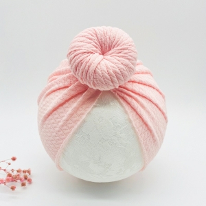 Rosa pannband för babyflicka på en vit boll med rosa blommor
