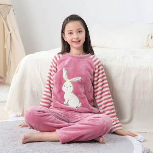 Varm kaninpyjamas med vita ränder för små flickor som bärs av en liten flicka i ett hus