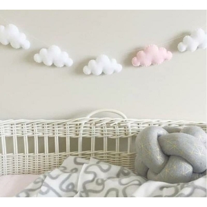 Dekoration för en flickas sovrum i form av ett vitt, rosa och grått moln som hänger ihop med en tråd ovanför en vit säng med grått täcke