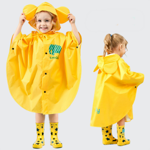 Gul mackintosh för barn som bärs av en liten flicka med gula och svarta regnstövlar