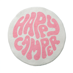En rund matta för ett vitt och rosa flickrum. Med texten "Happy camper" i mitten.