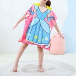 Strandhandduk för flickor med prinsessmotiv, bärs av en flicka som står på en grå matta