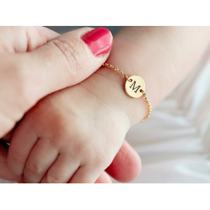 Armband med initialgravyr för flicka på en guldfärgad bebis handled med kedjelänk