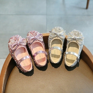 Princess ballerinas med glittrande fluga för flickor med en bordsbakgrund med skor