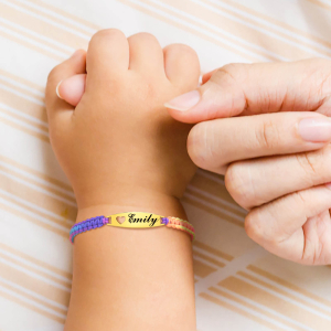 Barnhand med färgat armband på handleden och en vuxen kvinnas hand