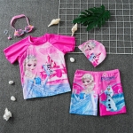 Rosa Snow Queen T-shirt och badshorts liggande på ett grått golv med keps och simglasögon