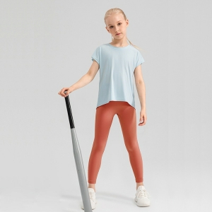 Ung blond tjej i sportkläder står med ett basebollträ i handen